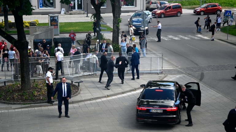 Bodyguards take Slovak Prime Minister Robert Fico in a car...