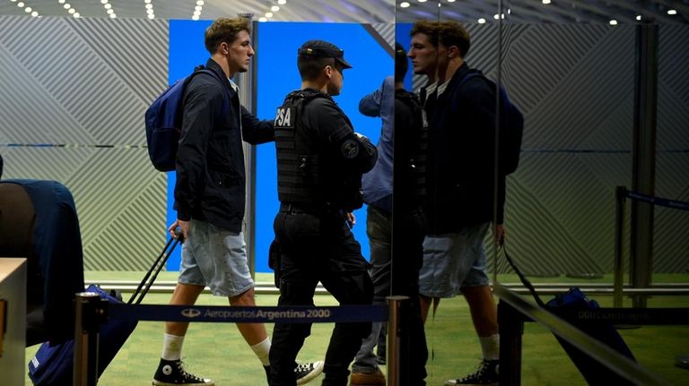 French rugby player Oscar Jegou, left, rolls a suitcase at...