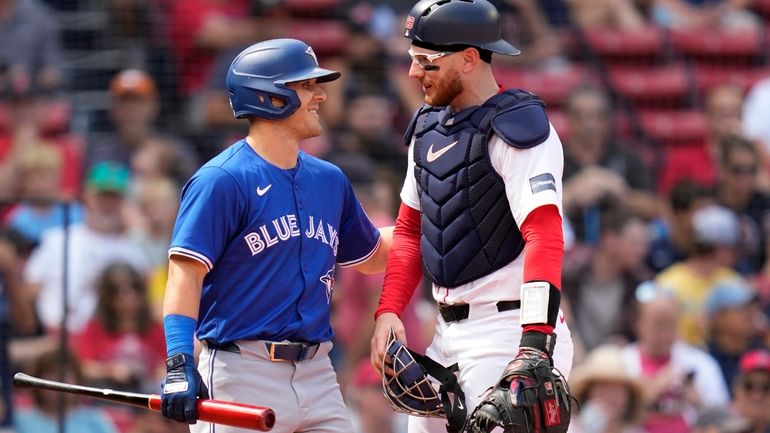 Boston Red Sox catcher Danny Jansen, right, gets a pat...