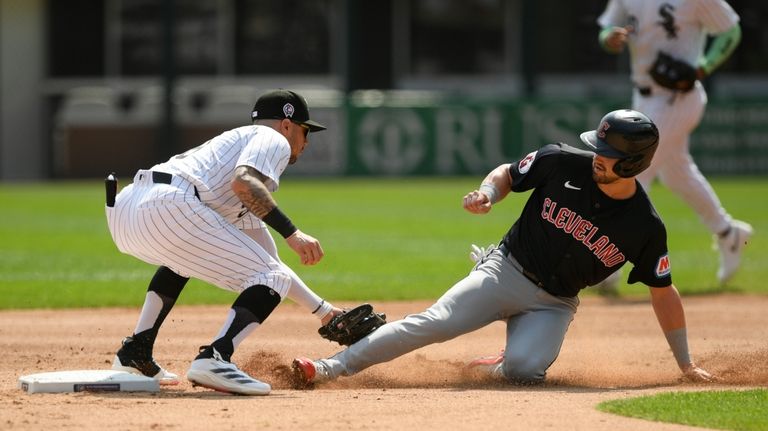 Cleveland Guardians' Lane Thomas, right, is tagged out at second...