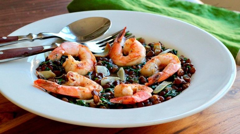 Seared shrimp atop simmered lentils with baby arugula.