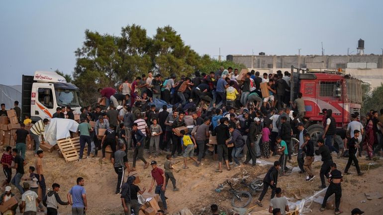 Palestinians are storming trucks loaded with humanitarian aid brought in...