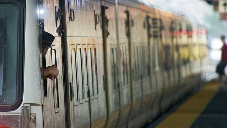 LIRR conductor checks a platform at Jamaica station as a...