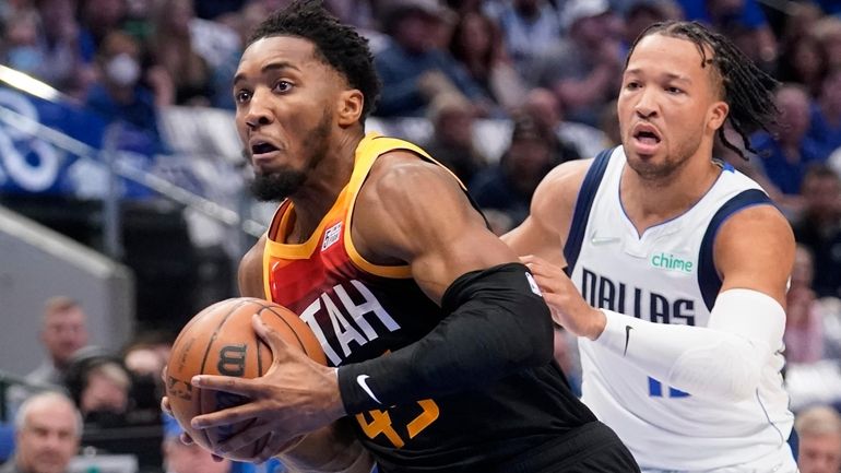 Jazz guard Donovan Mitchell drives to the basket past Mavericks...