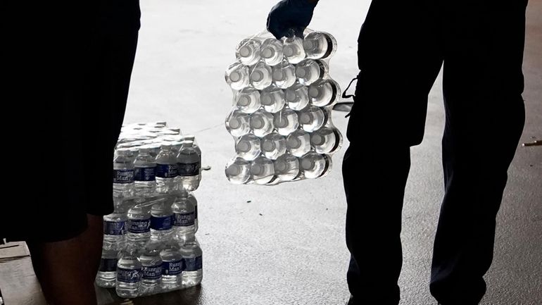 A recruit for the Jackson Fire Department carries a case...