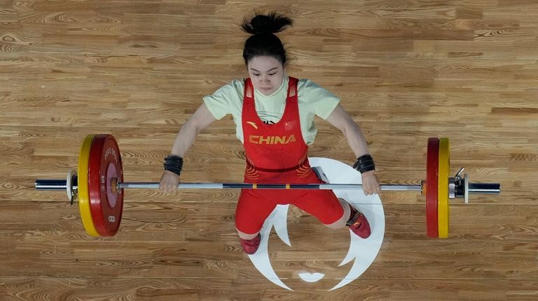 Luo Shifang of China competes during the women's 59kg weightlifting...