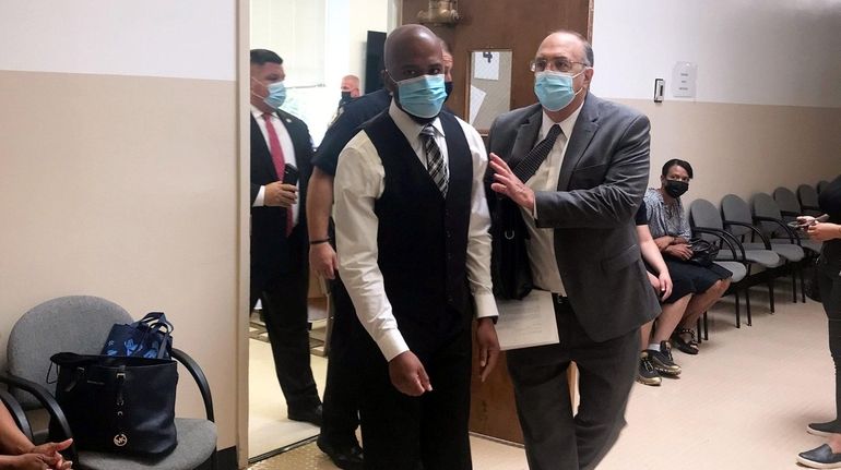 Nassau correction officer Harris Ferro (left) leaves the courtroom Friday...