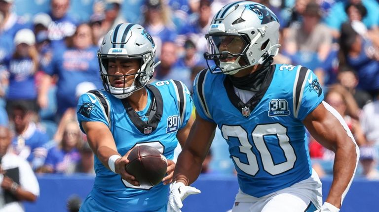 Carolina Panthers quarterback Bryce Young (9) fakes a handoff to...