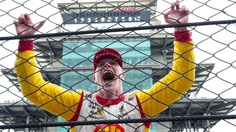 Josef Newgarden celebrates after winning the Indianapolis 500 auto race...