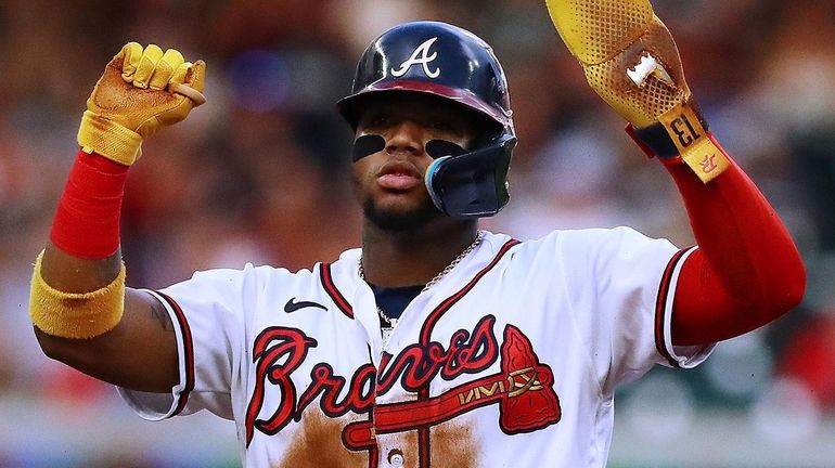 Atlanta's Ronald Acuna reacts to the team's dugout after stealing...