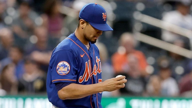 Carlos Carrasco #59 of the Mets looks at the ball...