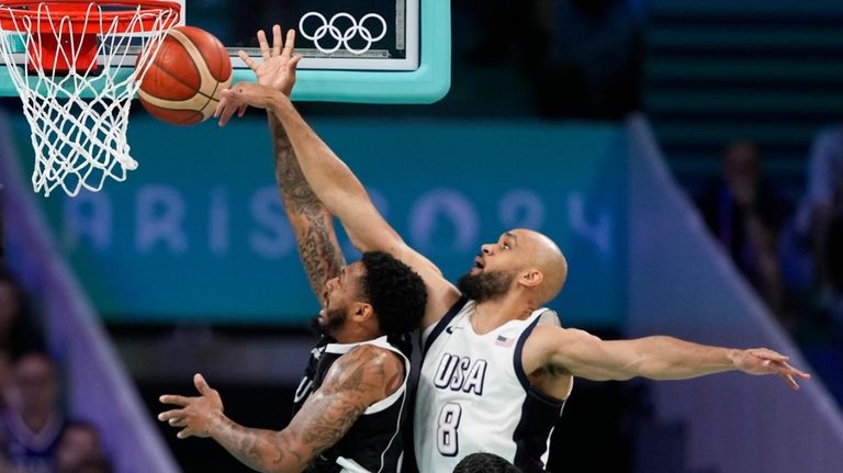 Derrick White, of the United States, blocks the shot of...