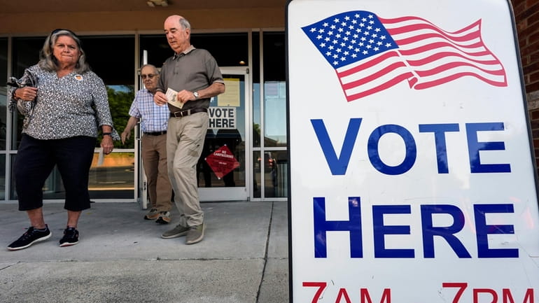 Voters depart an election center during primary voting, May 21,...