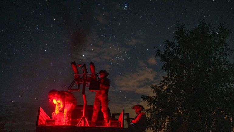 A volunteer for an air-defense unit prepares a machine gun...