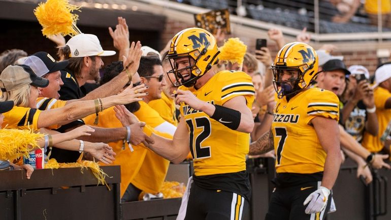 Missouri's Brady Cook, left, and Cody Schrader are congratulated by...