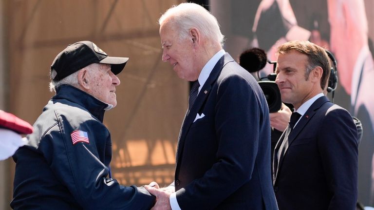 President Joe Biden and Emmanuel Macron greet a World War...