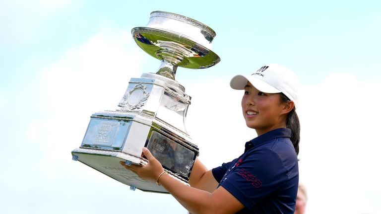 Ruoning Yin, of China, holds the trophy after winning the...