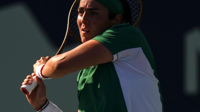 Tunisia's Ons Jabeur plays a shot against Japan's Naomi Osaka...