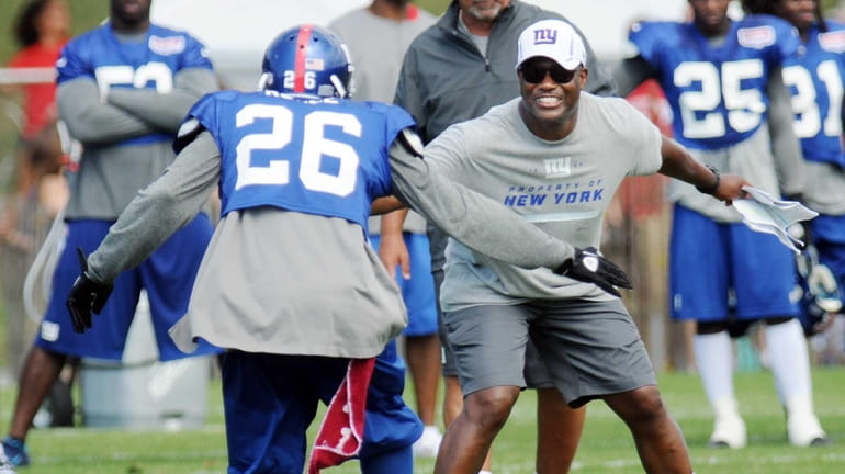 Antrel Rolle (26) celebrates a play with defensive coordinator Perry...