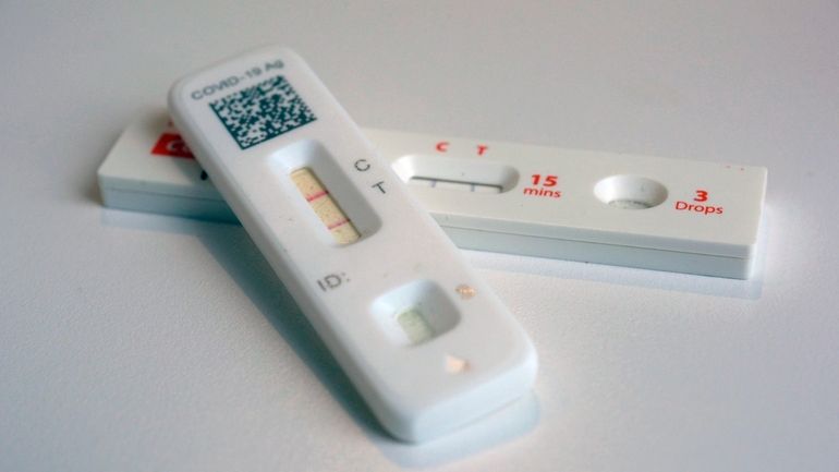 COVID-19 antigen home tests indicating a positive result are photographed...