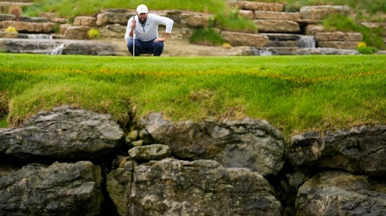 Scottie Scheffler lines up a putt on the 13th hole...