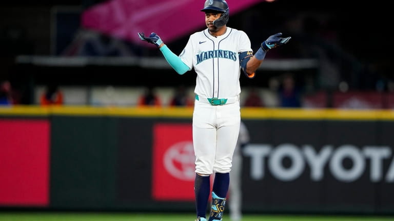 Seattle Mariners' Julio Rodríguez reacts after hitting an RBI single...