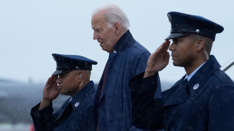 President Joe Biden walks down the steps of Air Force...