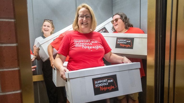 Corrin Day, from left, Cindy Maxwell-Ostdiek and Garrett Connely deliver...