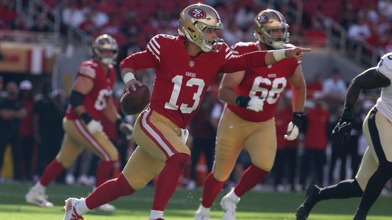 San Francisco 49ers quarterback Brock Purdy (13) signals to teammates...