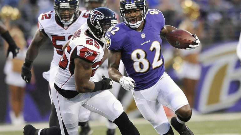 Baltimore Ravens wide receiver Torrey Smith carries the ball past...