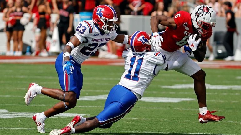 North Carolina State's Wesley Grimes (6) tries to break away...