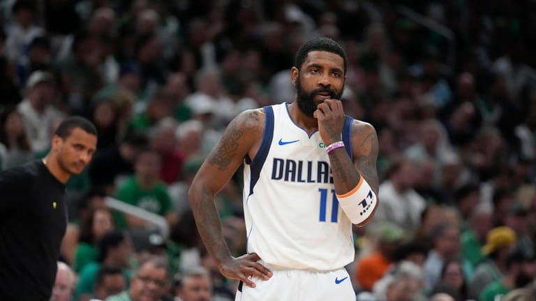 Dallas Mavericks guard Kyrie Irving pauses on the court in...