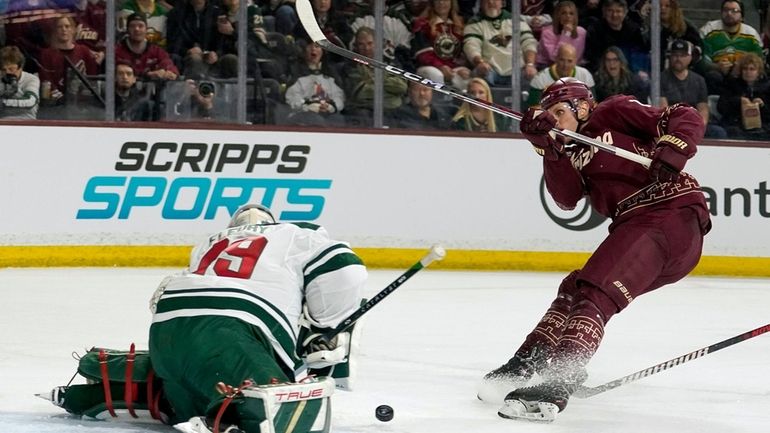 Arizona Coyotes' Nick Bjugstad, right, shoots against Minnesota Wild's goalie...