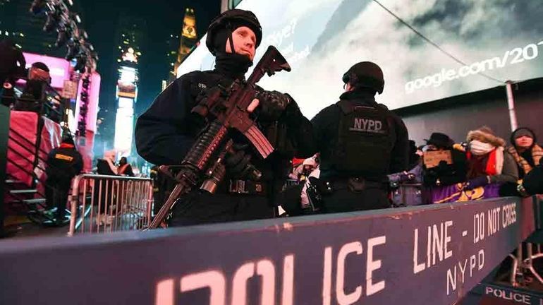 New York Police Department officers guard a street as people...