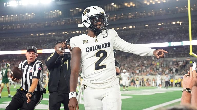 Colorado quarterback Shedeur Sanders gestures to fans after throwing a...