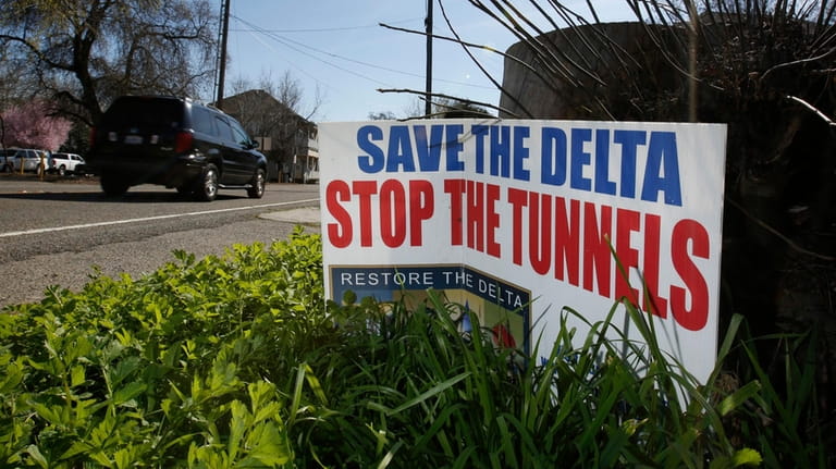 FILE – A sign opposing a plan to build a...