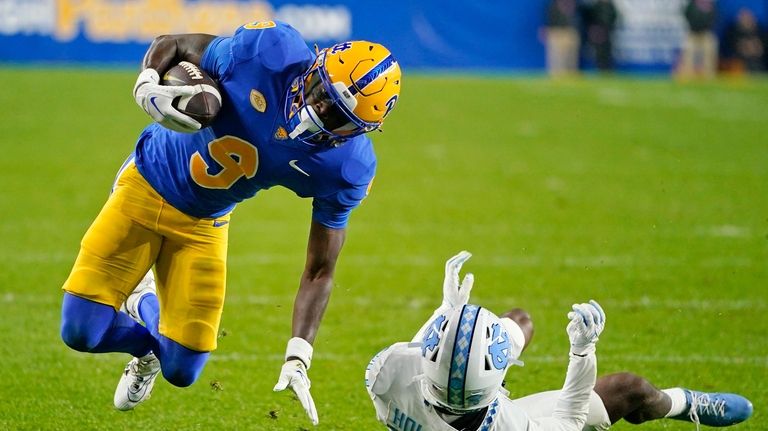 Pittsburgh wide receiver Konata Mumpfield (9) is upended by North...