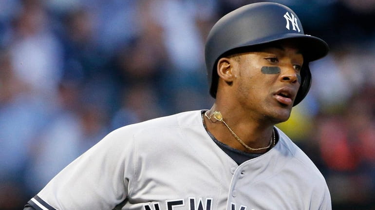 The Yankees' Miguel Andujar runs to first base after hitting...