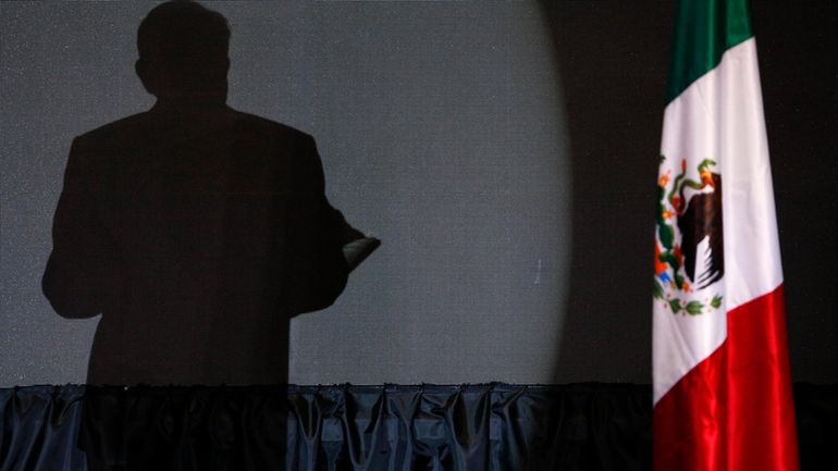 The shadow of presidential candidate Andres Manuel Lopez Obrador, founder...