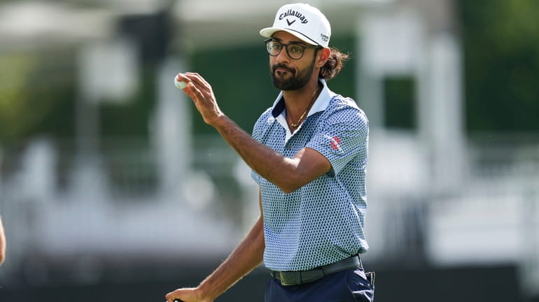 Akshay Bhatia waves after hitting his birdie putt on the...