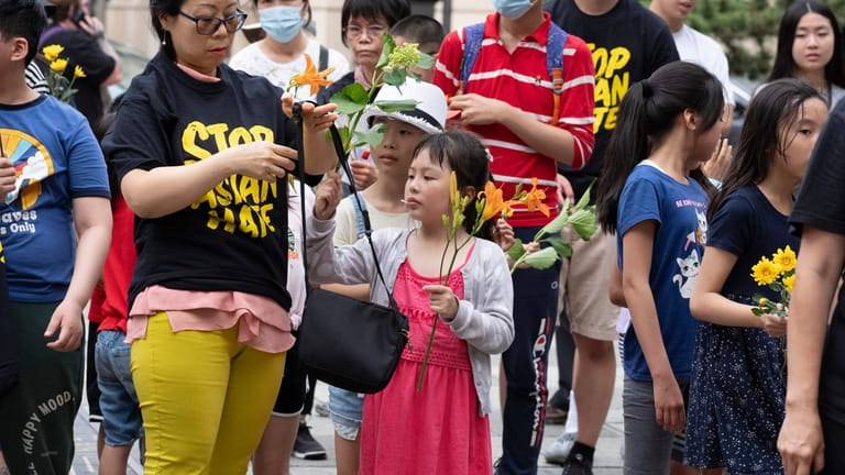 Children with flowers attend a remembrance ceremony for Vincent Chin...