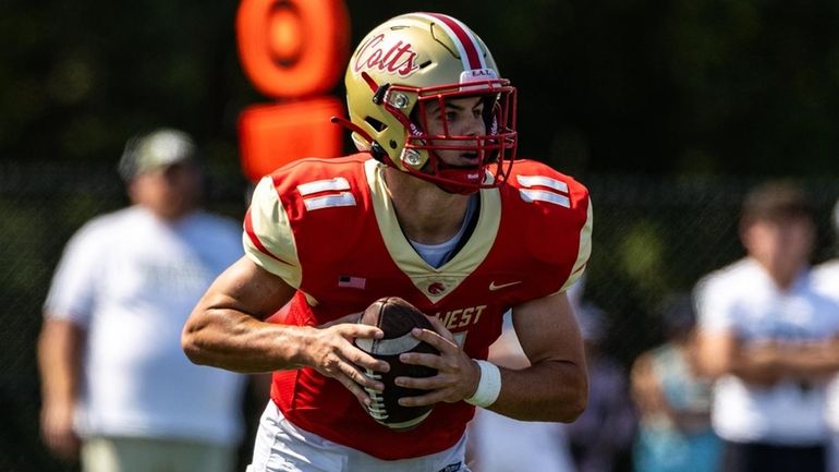 Half Hollow Hills West QB Joseph Filardi drops back to...