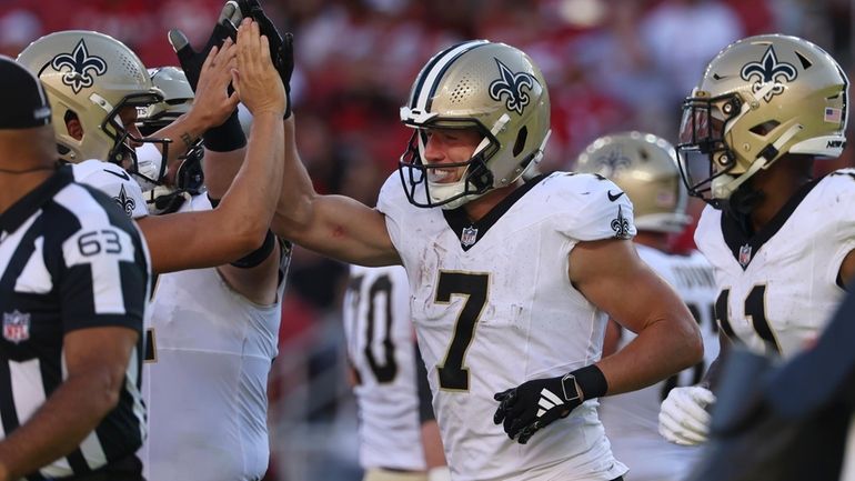 New Orleans Saints' Taysom Hill (7) is congratulated by teammates...