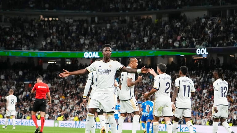 Real Madrid's Vinicius Junior, centre, celebrates after scoring his side's...