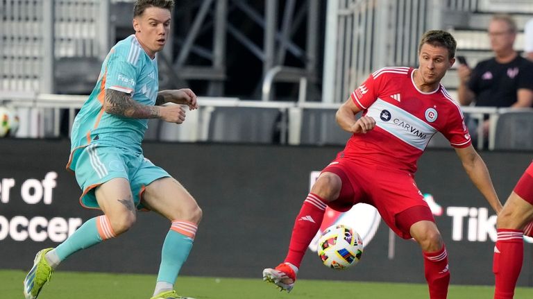 Chicago Fire defender Arnaud Souquet, right, controls the ball as...