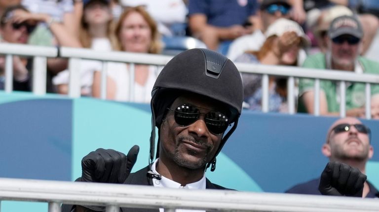 Snoop Dogg thumbs up as he watches the dressage team...