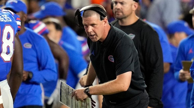 Florida head coach Billy Napier encourages his players during the...