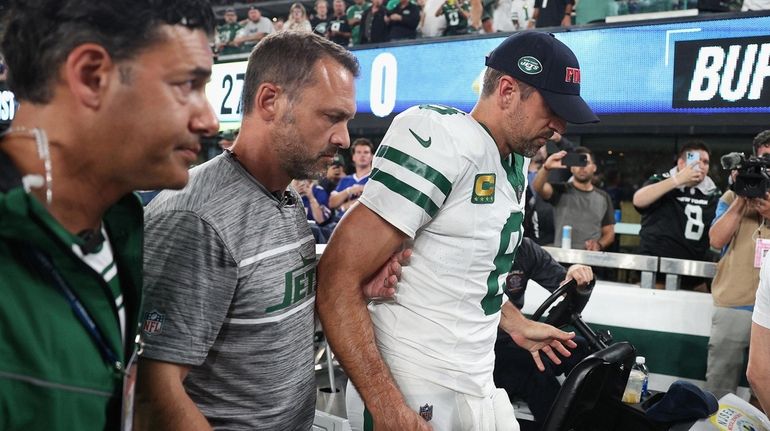 Jets quarterback Aaron Rodgers is helped off the field after...