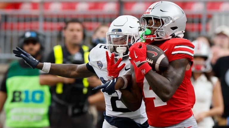 Ohio State receiver Jeremiah Smith, right, catches a pass in...