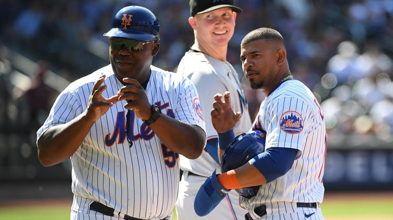 Mets first base coach Wayne Kirby and Eduardo Escobar gesture...